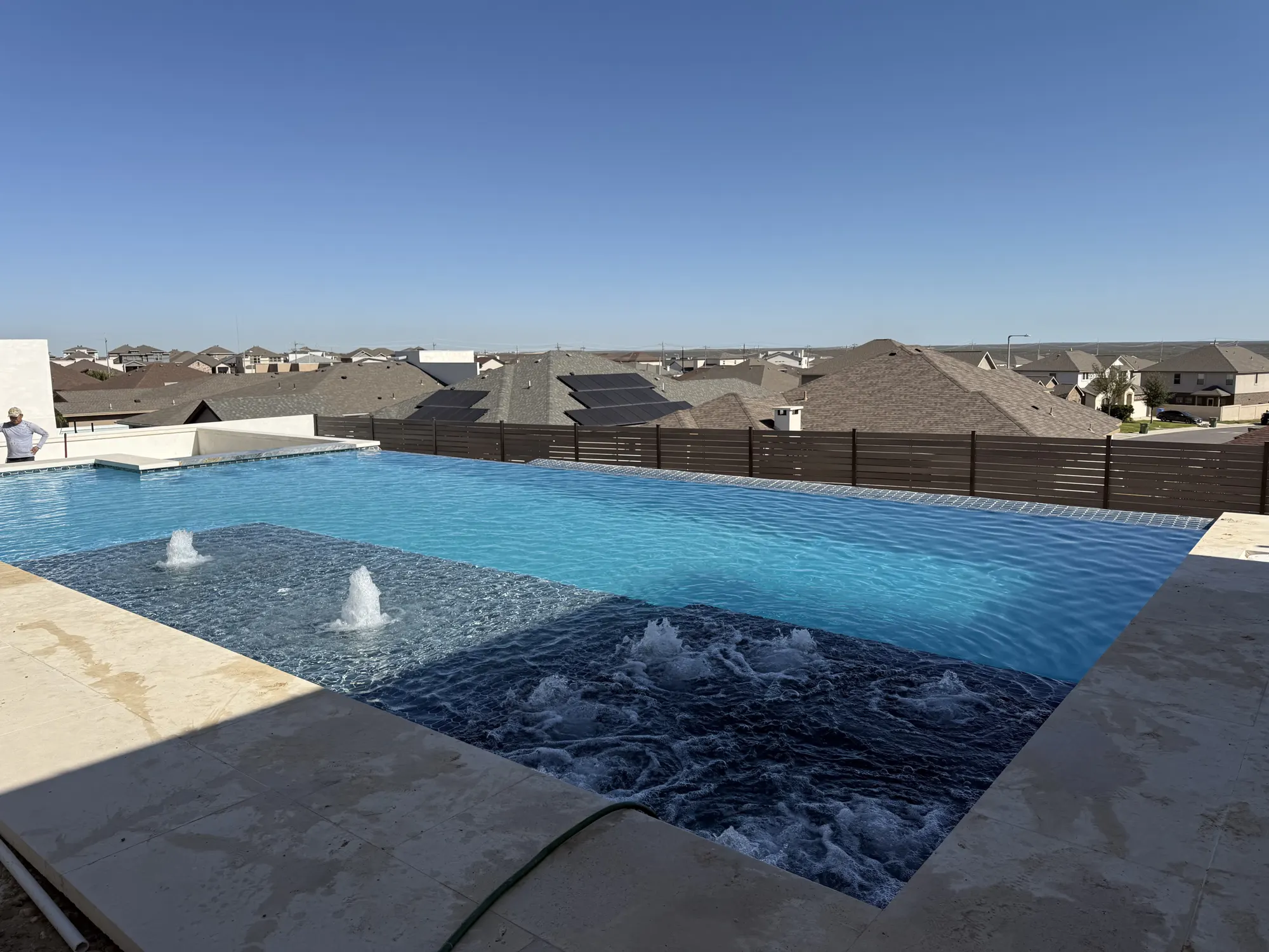 Rectangular pool with bubblers running in the shallow ledge, jets working the deep end and a stone deck around the edge
