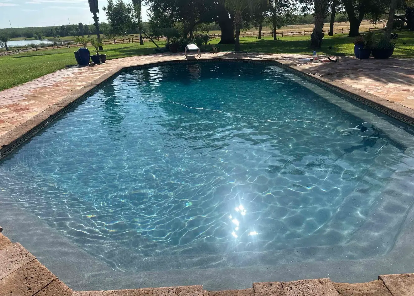 Large freeform JCW pool on a ranch property outside Laredo with open country behind it